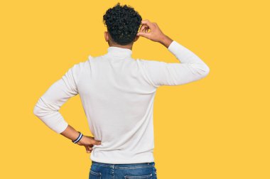 Genç Arap adam, günlük kışlık süveterini ters giyip elleri kafasında şüpheyi düşünüyor. 