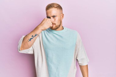 Gündelik kıyafetler giyen genç beyaz adam pis ve iğrenç bir koku alıyor, dayanılmaz bir koku, nefesini burnunda tutuyor. Kötü kokuyor. 