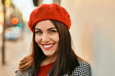 Genç İspanyol kadın gülümseyerek şehirde mutlu mesut dikiliyor..