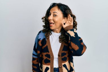 Orta yaşlı İspanyol kadın gündelik kıyafetler giyip sırıtarak kulaklarını tıkayıp dedikoduları ve dedikoduları dinliyor. Sağırlık kavramı. 