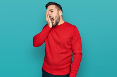 Latin asıllı genç bir adam günlük kıyafetler giyiyor. Yarı yüzünü, göz ve ağzını eliyle kapatmaktan yoruluyor. Yüzüm acıyor.. 