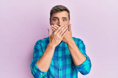 Sıradan kıyafetler giyen yakışıklı beyaz adam yanlışlıkla elleri ile ağzını kapatırken şok oldu. gizli kavram. 