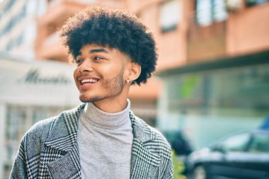 Genç Afrikalı Amerikalı iş adamı şehirde mutlu mesut dikiliyor..