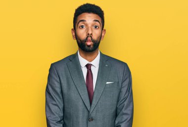 Genç Afrikalı Amerikalı iş kıyafetleri giymiş dudaklarıyla balık suratı yapan çılgın ve komik bir jest. Komik ifade. 