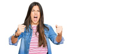 Genç esmer kadın, kızgın ve kızgın. Öfkeyle bağırırken yumruklarını kaldırıyor. öfke ve agresif konsept. 