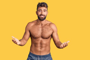 Mayo giyen genç İspanyol bir adam kolları ve elleri havada, aptal ve kafası karışık bir ifade takınıyor. şüphe kavramı. 