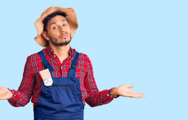 Yakışıklı Latin Amerikalı genç adam, tamirci üniforması giyiyor. Hiçbir şeyden habersiz ve kolları açık, hiçbir fikri yok.. 