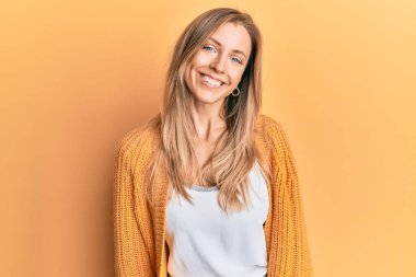 Yüzünde mutlu ve havalı bir gülümseme olan günlük kıyafetler giyen güzel beyaz bir kadın. şanslı kişi. 