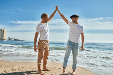 Genç eşcinsel çift gülümsüyor Kumsalda dans ederken mutlu.