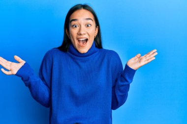 Sıradan bir kazak giyen genç Asyalı kadın çılgın ve başarıyı kollarını kaldırıp heyecanla haykırarak kutluyor. Kazanan konsept 