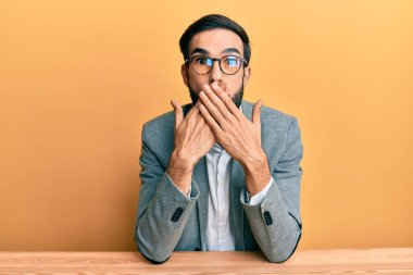 Ofiste çalışan genç bir İspanyol yanlışlıkla ağzı ellerle kapatırken şok oldu. gizli kavram. 