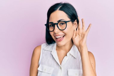 Güzel genç bir kadın pembe kanser kurdelesini kuşkucu ve gergin tutuyor. Yüzünde çapraz kollarla onaylamayan bir ifade var. negatif kişi. 