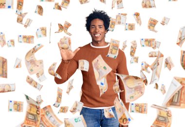 Yakışıklı Afro saçlı, sıradan giyinmiş, 5 numarayı işaret eden, kendinden emin ve mutlu gülümseyen Afro-Amerikan adam..