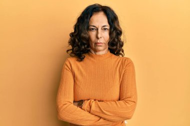Orta yaşlı İspanyol kadın gündelik kıyafetler giyiyor. Kuşkucu ve gergin. Yüzünde çapraz kollu tasvip etmeyen bir ifade. negatif kişi. 