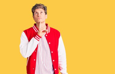 Beyzbol üniforması giyen yakışıklı genç adam şüpheye odaklanmıştı. Parmakları çenesinde ve yukarı bakıyordu. 