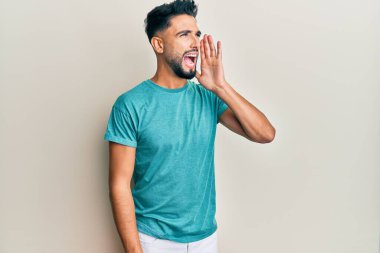 Sakallı genç adam gündelik giysiler giyip el ele tutuşarak bağırıyor ve çığlık atıyordu. iletişim konsepti. 