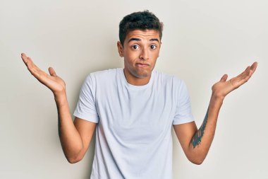 Genç, yakışıklı, Afro-Amerikalı bir adam, günlük beyaz tişört giyiyor. Hiçbir şeyden habersiz, kolları açık, hiçbir fikri yok ve şüpheli bir yüzü var.. 