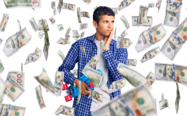 Genç Afrikalı Amerikalı bir adam ciddi bir yüz ifadesi takınarak eli çenesinde soru sormayı düşünüyor. Kafa karıştırıcı bir fikir.