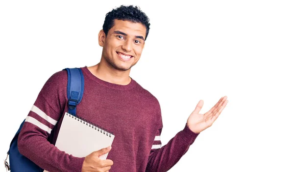 Joven Joven Guapo Hispano Con Mochila Estudiantil Cuaderno Celebrando Victoria —  Fotos de Stock