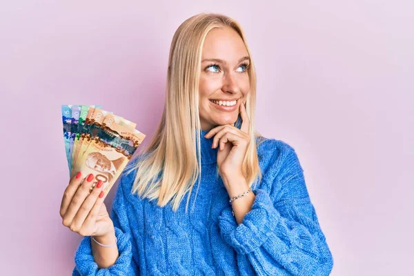 Mladá Blondýnka Drží Kanadské Dolary Rukou Bradě Přemýšlí Otázce Zamyšleném — Stock fotografie