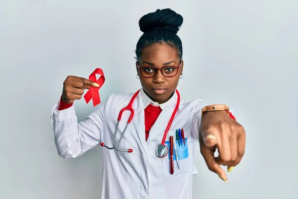 Joven Mujer Afroamericana Vistiendo Uniforme Médico Sosteniendo Cinta Roja Apoyo —  Fotos de Stock