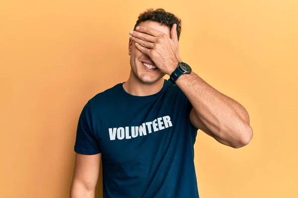 Jovem Hispânico Vestindo Camiseta Voluntária Cobrindo Olhos Com Mão Parecendo — Fotografia de Stock