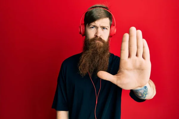 Uzun Sakallı Kulaklık Takıp Müzik Dinleyen Kızıl Saçlı Adam Avucunun — Stok fotoğraf
