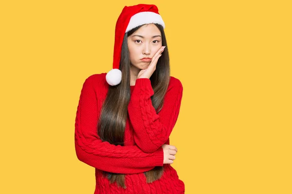 若いです中国の女性身に着けていますクリスマス帽子考え疲れていると退屈とともにうつ病問題とともに交差腕 — ストック写真