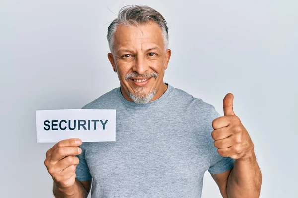 Hombre Pelo Gris Mediana Edad Sosteniendo Papel Palabra Seguridad Sonriendo —  Fotos de Stock