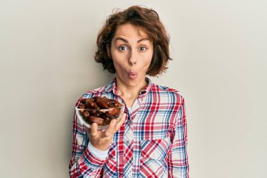 Genç esmer kadın elinde kaseyle buluşuyor. Korkmuş ve ağzı açık kalmış, şaşırmış, inançsız bir yüz. 