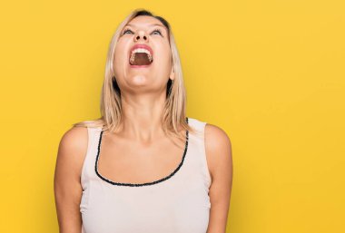 Orta yaşlı beyaz kadın, günlük kıyafetler giyiyor kızgın ve kızgın bağırıyor sinirli ve öfkeli, öfkeyle bağırıyor. öfke ve agresif konsept. 