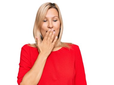 Orta yaşlı, günlük kıyafetler giyen beyaz bir kadın ağzını eliyle kapatmaktan sıkılmış. Huzursuz ve uykulu.. 