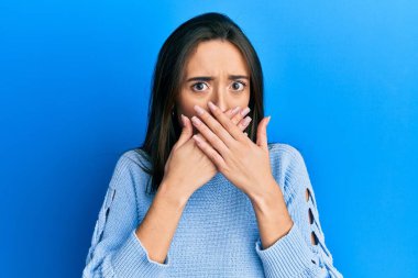 Gündelik kıyafetler giyen genç İspanyol kız yanlışlıkla elleri ile ağzını kapatırken şok oldu. gizli kavram. 