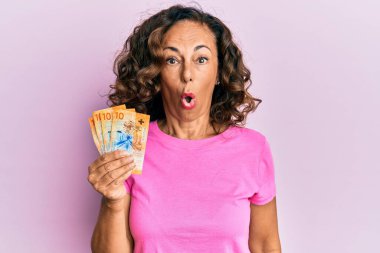 Orta yaşlı İspanyol kadın elinde İsviçre frangı banknotları tutuyor. Şaşırtıcı bir şekilde korkmuş ve hayrete düşmüştü. İnanmayan yüz. 