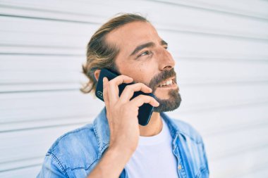 Ortadoğulu genç adam şehirdeki akıllı telefondan konuşuyor..