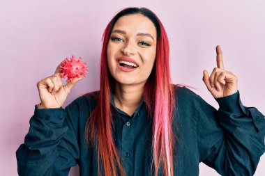 Elinde virüs oyuncağı olan beyaz bir kadın bir fikre ya da soru işaretine şaşırdı ve mutlu bir yüzle işaret etti. 