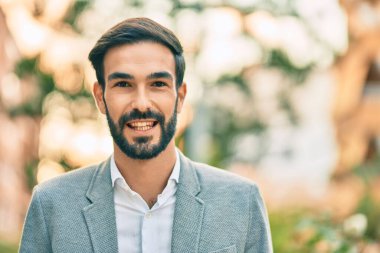 Genç İspanyol işadamı gülümseyerek şehirde mutlu mesut duruyor..