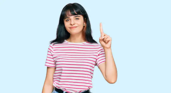 Młoda Latynoska Dziewczyna Luźnych Ubraniach Pokazując Wskazując Palcem Numer Jeden — Zdjęcie stockowe