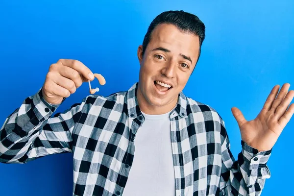 Joven Guapo Sosteniendo Audífono Médico Celebrando Logro Con Sonrisa Feliz —  Fotos de Stock