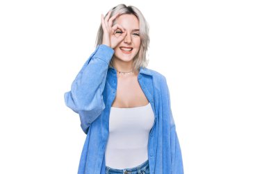 Sıradan kıyafetler giyen genç sarışın kız el hareketleriyle gülümsüyor, mutlu yüzle parmaklarının arasından bakıyor.. 