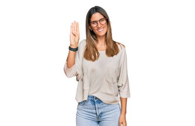 Gündelik kıyafetler giyen ve gözlük takan genç bir kadın gülümseyerek kendinden emin ve mutlu bir şekilde dört numarayı gösteriyor ve işaret ediyor.. 