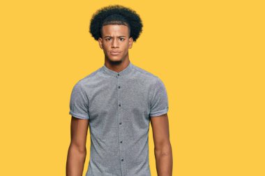Afro saçlı, sıradan giyinen, şüpheci ve gergin bir Afro-Amerikalı sorun yüzünden surat asıyor. negatif kişi. 