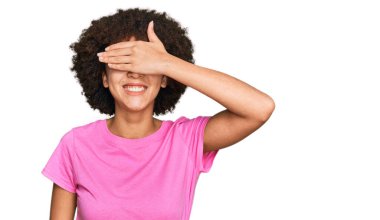 Günlük kıyafetler giyen, gülümseyen ve gülen genç İspanyol kız şaşırmak için gözlerini kapatıyor. kör kavram. 