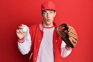 Beyzbol üniforması giyen yakışıklı beyaz adam elinde Golve ve topuyla balık suratlı ve şaşı gözlü, çılgın ve komik.. 