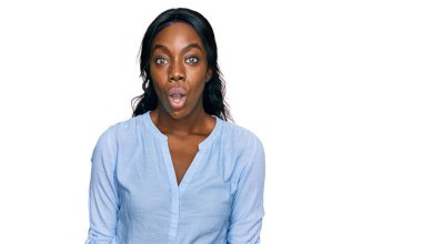 Genç Afro-Amerikalı kadın günlük kıyafetler giyiyor. Korkmuş ve ağzı açık kalmış, şaşırmış ve şaşırmış. İnanmayan yüz. 