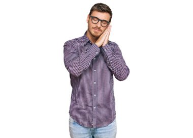 Yakışıklı beyaz bir adam günlük kıyafetler ve gözlük takıyor. Uyuyor, yorgun düşler görüyor ve elleri ile poz veriyor. Gözleri kapalı gülümsüyor.. 