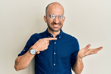 Gündelik kıyafetler giyen ve gözlüklü genç İspanyol adam kameraya hayret ediyor ve gülümsüyor.. 