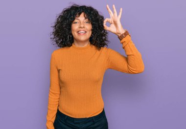 Gündelik kıyafetler giyen, gülümseyen genç İspanyol kadın el ve parmaklarıyla 