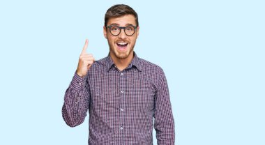 Sıradan kıyafetler ve gözlük takan yakışıklı beyaz adam başarılı bir fikirle işaret ediyor. Heyecanlı ve mutlu. Bir numara.. 