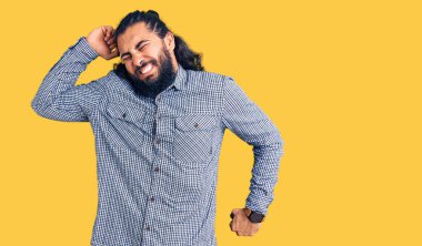 Genç Arap adam gündelik giysiler giyiyor, geriniyor, yorgun ve rahat, uykulu ve sabahın erken saatlerinde esniyor. 